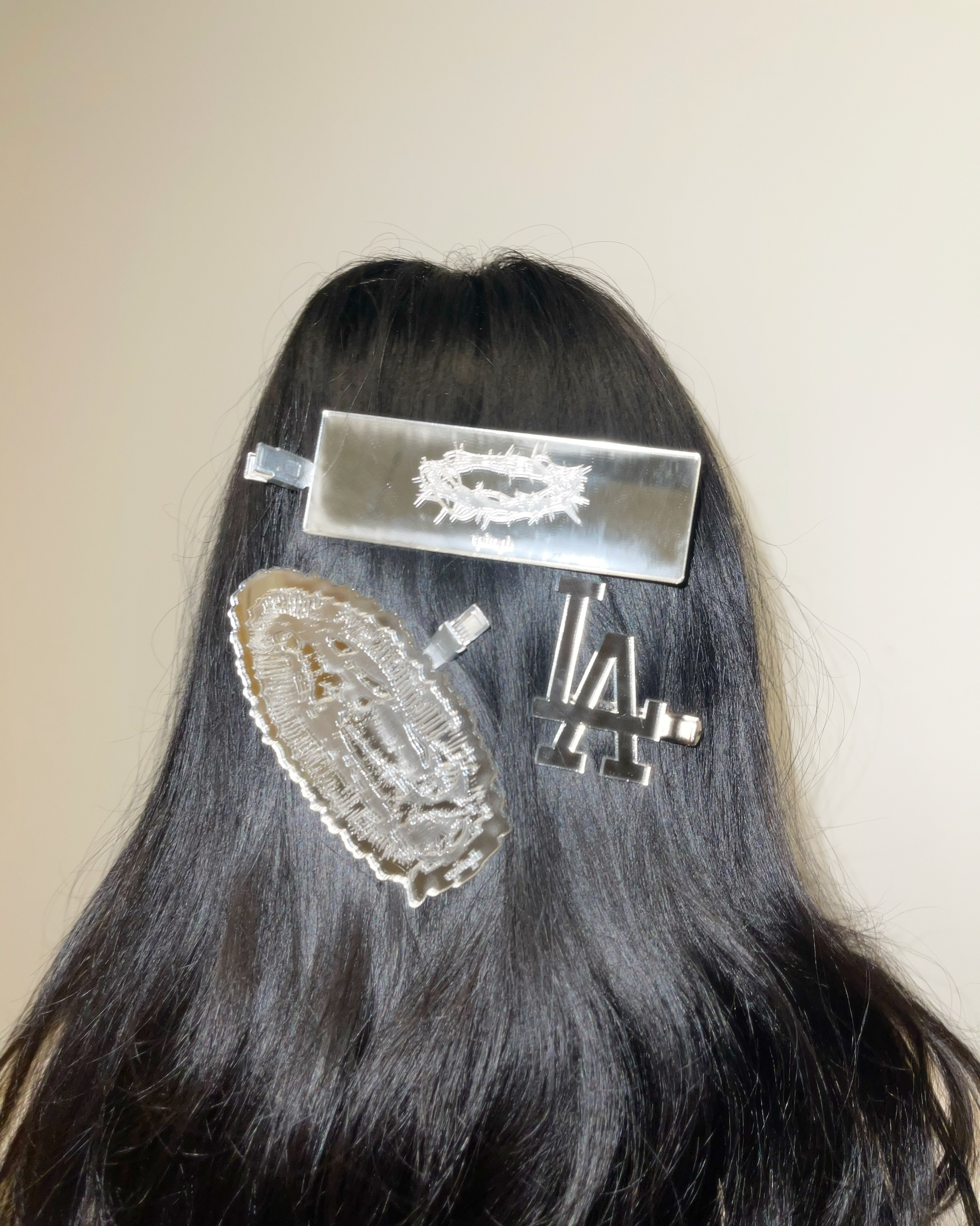 Clock up photo of a black wig with acrylic clips on it.